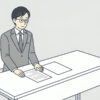 机の上に紙が二枚。左の紙には行が書かれ、右の紙は白紙