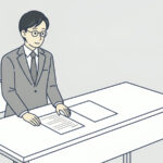 机の上に紙が二枚。左の紙には行が書かれ、右の紙は白紙