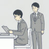 机で書類を読み込む40代の男性社員と、その背後に立って声をかけられずにいる若手の上司のイラスト