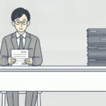 一人が紙1枚だけを見ている机と、隣に紙が高く積まれた机の図