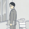 夕方のオフィスの窓際で外を見ている会社員