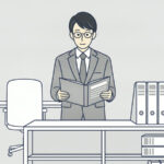 書類棚の前でファイルを開いている会社員