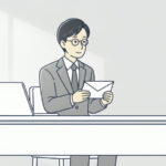 机で白い封筒を手に取って見ている会社員